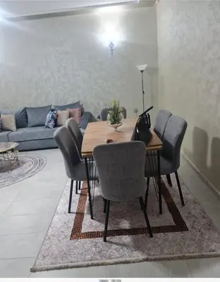 a dining room with a table and chairs and a couch at Marbella Beach Almansouria in Mansouria