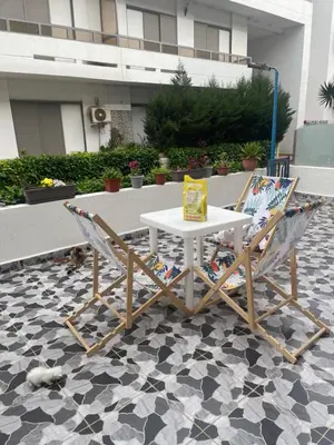 a white table and two chairs on a patio at Marbella Beach Almansouria in Mansouria