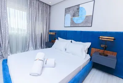 a hotel room with a white bed and a blue wall at Chic & Spacious : 3BR Apartment in Central Rabat in Rabat