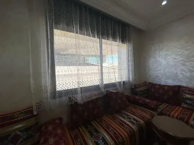 a living room with a couch and a window at appart casa voyageurs belvédère in Casablanca
