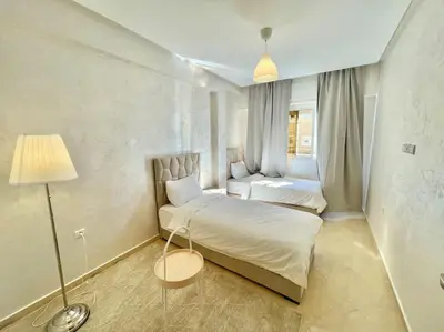 a small bedroom with a bed and a lamp at F4 Appartement entièrement neuf au cœur de Témara in Temara