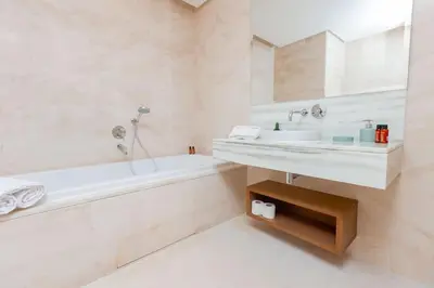 a white bathroom with a tub and a sink at Aristocratic Abode: Luxurious 2BR Flat in Agdal in Rabat