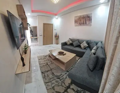 a living room with a blue couch and a table at Zenata ocean park appartement in Mohammedia