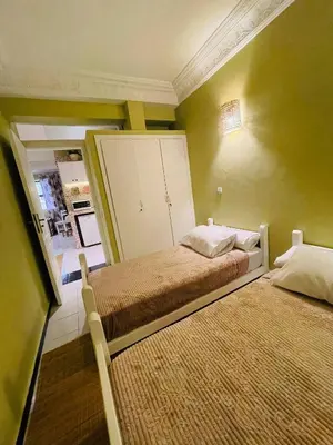 two beds in a small room with green walls at Beautiful Studio In Casablanca in Casablanca
