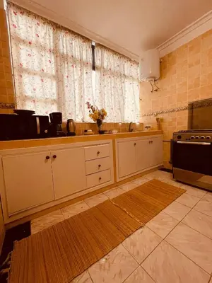 a kitchen with white cabinets and a window at Magnificent studio for two in the center of Casablanca in Casablanca
