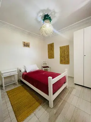 a bedroom with a bed and a chandelier at Coquet Appartement Casablanca in Casablanca