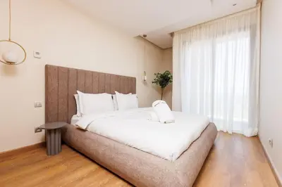 a bedroom with a large white bed and a window at Stylish 1BR flat in Hay Riad Central Rabat in Rabat