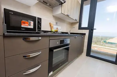 a kitchen with a stove and a microwave at Stylish 1BR flat in Hay Riad Central Rabat in Rabat