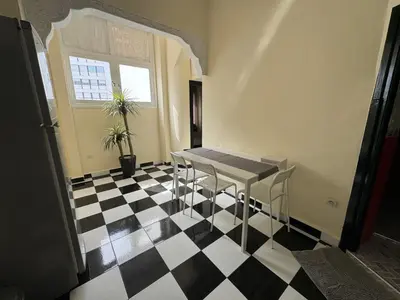 a room with a table and chairs on a checkered floor at Casablanca Central Suites - Casa Port in Casablanca