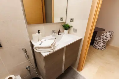 a bathroom with a sink and a mirror at Central Charm: 1-Bed Apartment in Hay Riad in Rabat