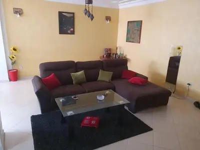 a living room with a brown couch and a coffee table at Appartement spacieux, exceptionnel in Temara