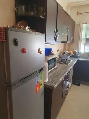 a kitchen with a refrigerator with magnets on it at Appartement spacieux, exceptionnel in Temara