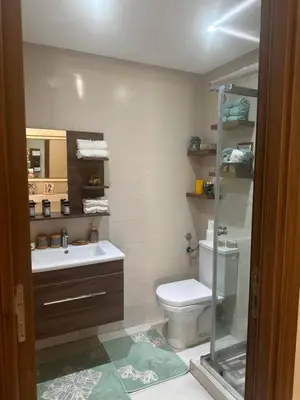 a bathroom with a toilet and a sink and a shower at Belle appartement tout neuf in Bouznika