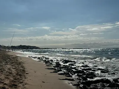 a beach with a bunch of rocks in the water at Belle appartement tout neuf in Bouznika