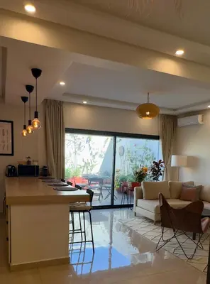 a kitchen and living room with a couch and a table at Cozy 2 bedrooms flat at Dar Bouazza in Dar Bouazza
