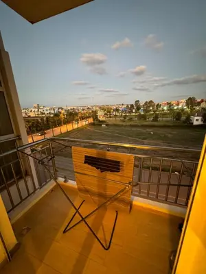 a chair on a balcony with a view of a parking lot at Bouznika Beach appartement de luxe avec piscine in Bouznika