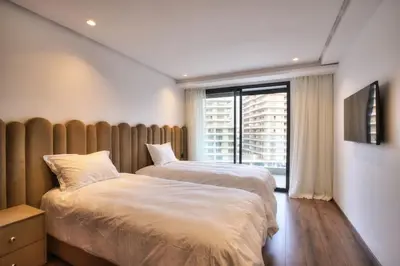two beds in a room with a window at Appart en face de la tour CFC in Casablanca