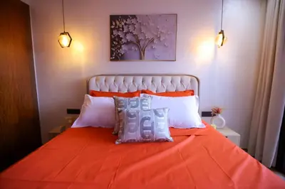a bedroom with an orange bed with white pillows at Modern Cozy Ghandi District in Casablanca