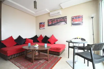 a living room with a red couch and a table at Appartement Panoramique in Casablanca