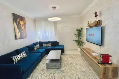 a living room with a blue couch and a tv at T6 Appartement entièrement neuf au cœur de Témara in Temara