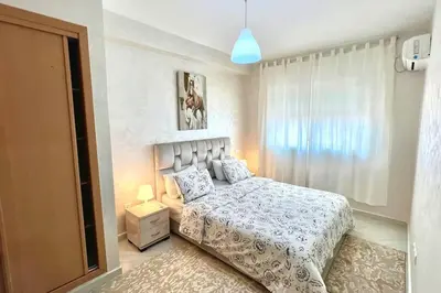a small bedroom with a bed and a window at T6 Appartement entièrement neuf au cœur de Témara in Temara
