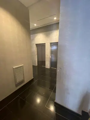 a hallway with a white wall and a tile floor at prestigieuse à casa finance city in Casablanca
