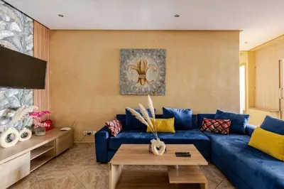 a living room with a blue couch and a table at Appartement Cosy Agdal Centre Rabat in Rabat