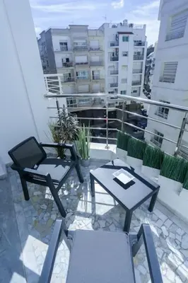 a patio with two tables and chairs on a balcony at Résidence Windsor in Casablanca