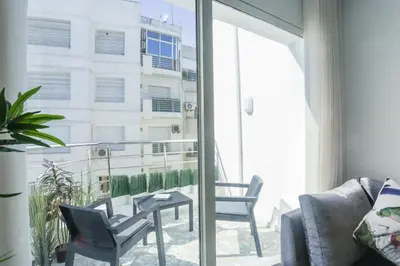 a living room with a table and chairs on a balcony at Résidence Windsor in Casablanca