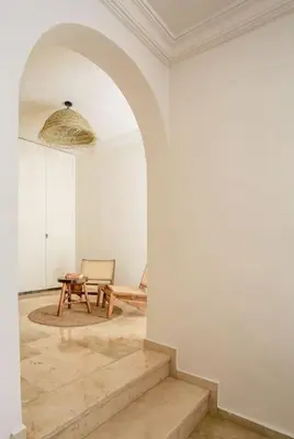 an archway in a room with a table and a chair at Résidence La Fontaine - Racine in Casablanca
