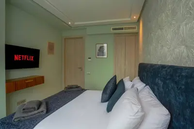 a bedroom with a bed with pillows and a television at Résidence Anfa Sunset - Ain Diab Casablanca Beach in Casablanca