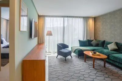 a living room with a green couch and a table at Résidence Anfa Sunset - Ain Diab Casablanca Beach in Casablanca
