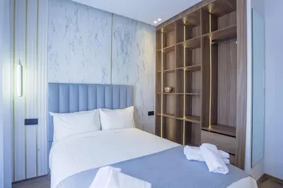 a bedroom with a bed with white sheets and a blue headboard at Résidence Palm - Palmiers in Casablanca