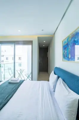 a bedroom with a white bed and a large window at Résidence Ronomo - Racine in Casablanca