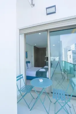 a balcony with a bed and a table and chairs at Résidence Ronomo - Racine in Casablanca