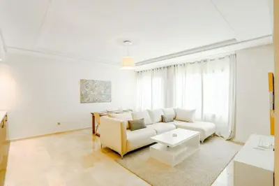 a white living room with a couch and a table at Résidence Urban Square D52 in Casablanca
