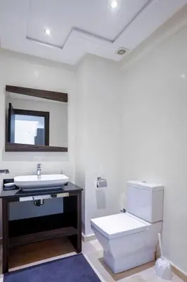 a bathroom with a sink and a toilet and a mirror at Résidence Urban Square D52 in Casablanca