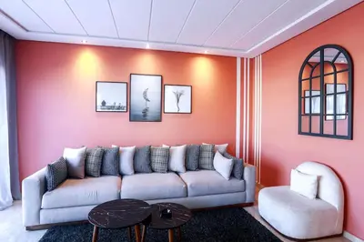 a living room with a couch and a red wall at Résidence Smalto - Bd Anfa in Casablanca