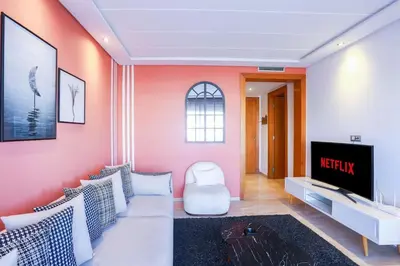 a living room with a couch and a tv at Résidence Smalto - Bd Anfa in Casablanca