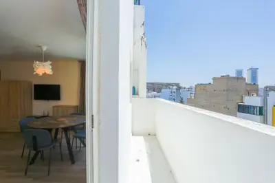 a balcony with a table and chairs and a view of a city at Résidence Bd Anfa in Casablanca
