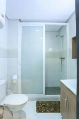 a white bathroom with a shower and a toilet at Résidence Bd Anfa in Casablanca