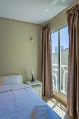 a bedroom with a bed and a large window at Résidence Bd Anfa in Casablanca