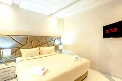 a bedroom with a bed and a tv on the wall at Résidence Sheren - Maarif in Casablanca