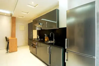 a large kitchen with a stainless steel refrigerator at Résidence Sheren - Maarif in Casablanca
