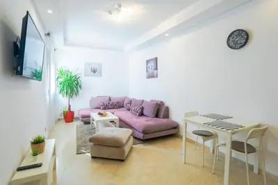 a living room with a pink couch and a table at Résidence Liberté in Casablanca