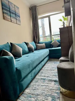 a blue couch in a living room with a window at Appartement Moderne à OlaBlanca2 in Sidi Rahal