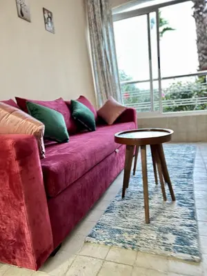 a living room with a purple couch and a table at Appartement Moderne à OlaBlanca2 in Sidi Rahal