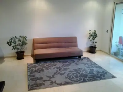 a brown couch in a living room with a rug at Appartement Bella Vista in Bouznika