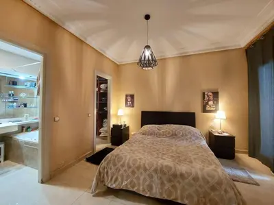 a bedroom with a large bed and a bathroom at Appartement chic avec Terrasse in Casablanca
