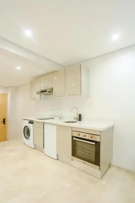 a white kitchen with a sink and a dishwasher at Résidence de Nice in Casablanca
